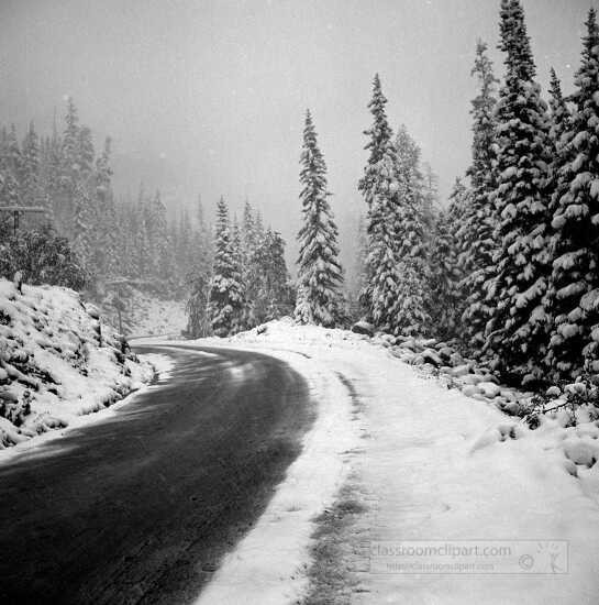 Highway in snow covered mountains during early fall blizzard