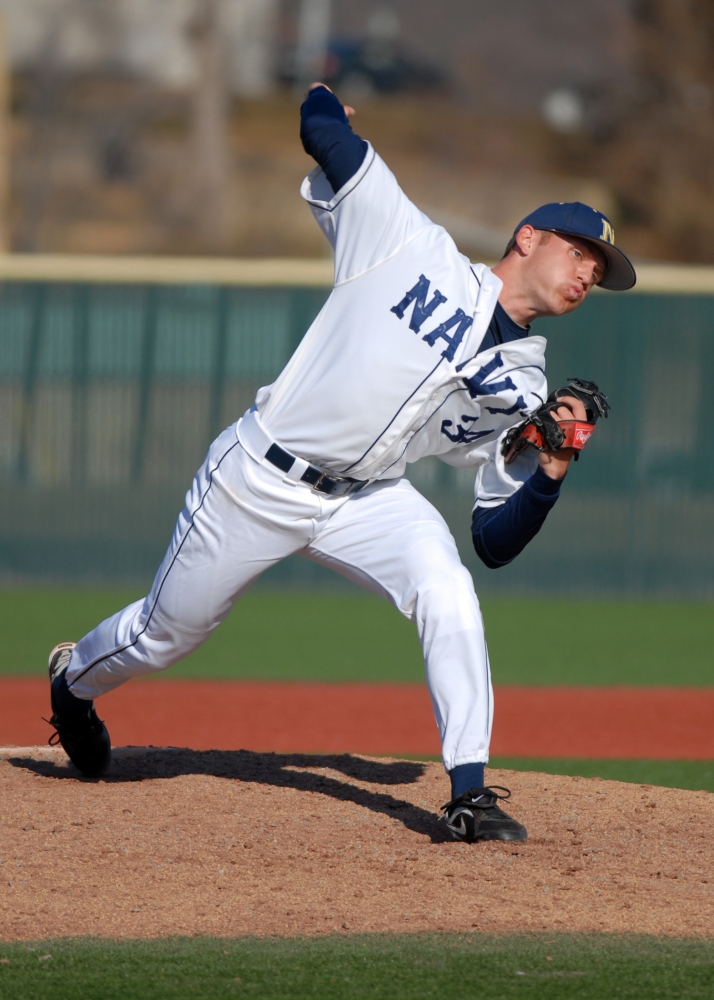 navy baseball player throwing pitch