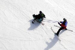  adaptive skier receives guidance from an instructor on a snowy 