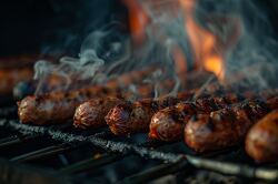 barbecue with several charred browned sausages