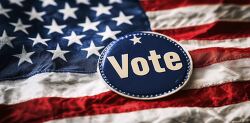 close up of a Vote button against the backdrop of the US flag