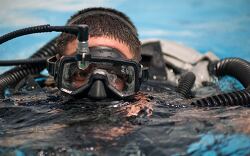 cuba diver emerges from the water, wearing a mask and breathing 