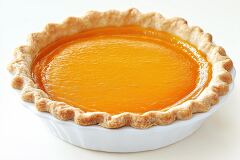 This delectable pumpkin pie features a smooth, glossy orange filling encased in a perfectly baked golden brown crust, all served in a white pie dish against a light background.