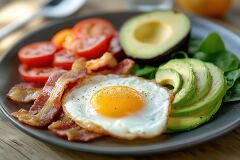 hearty breakfast of fried eggs avocado bacon and fresh vegetable