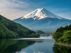 A breathtaking view captures Mount Fuji standing tall, its snow capped peak mirrored in the calm waters of a serene lake, surrounded by lush green hills under a blue sky.