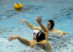 players in a water polo match with one player attempting to thro