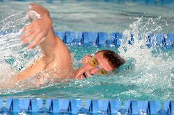 swimmer performs the freestyle stroke in a swimming pool, wearin
