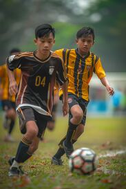 two soccer players wearing uniforms