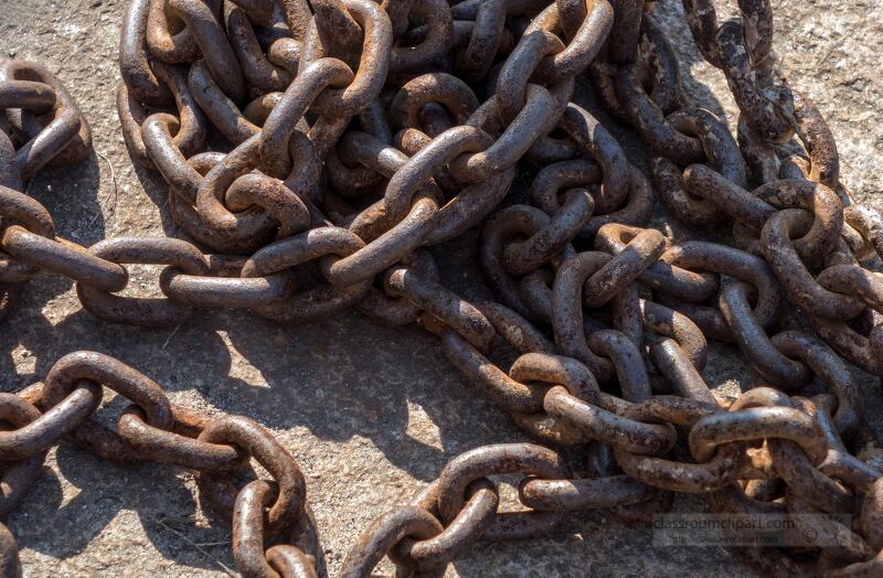 Close up of intertwined rusty metal chains on the ground