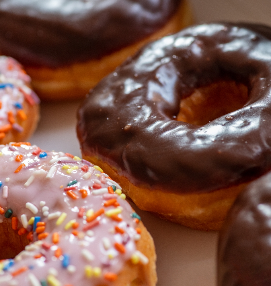 doughnuts covered with chocolate icing and sprinkes