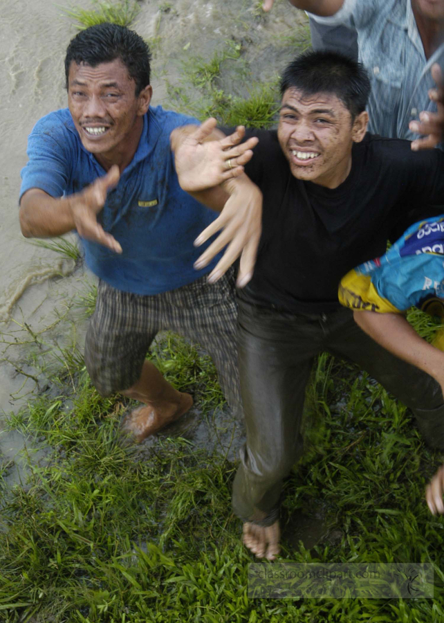 men from a small village reach to catch food from helicopter