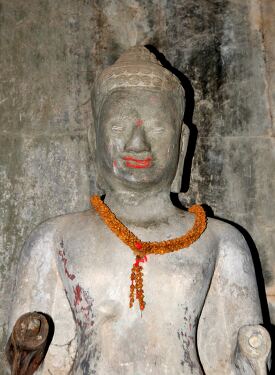 Intricate Stone Statue Adorned With Flowers in Siem Reap