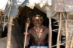 Samburu Tribesman in Traditional Attire at Village Entrance