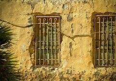 Textured Yellow Walls and Barred Windows in Aswan Egypt