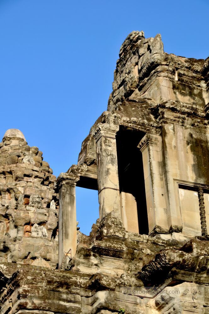 Magnificent stone structures rise against the pristine blue sky in Siem Reap. The intricate carvings and weathered stones showcase the history and artistry of Angkor Wat inviting exploration and admiration.