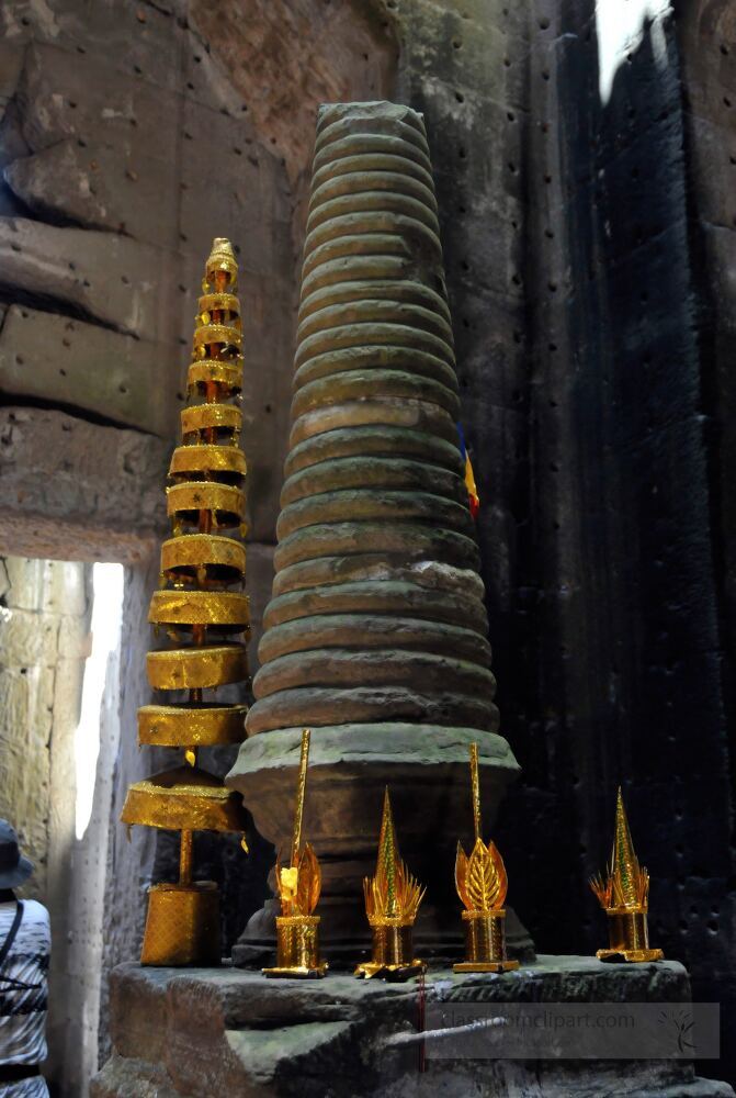 Inside Angkor Wat golden offerings adorn ancient stone structures reflecting the rich spiritual heritage of Cambodia. Visitors explore the stunning architecture and cultural significance of this historic site.