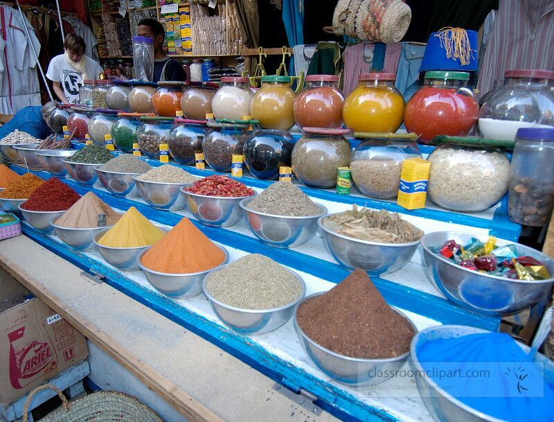 Vibrant spices are arranged in bowls at a bustling market in Aswan Egypt Customers browse the assortment of colorful powders and ingredients showcasing the rich culinary heritage of the region