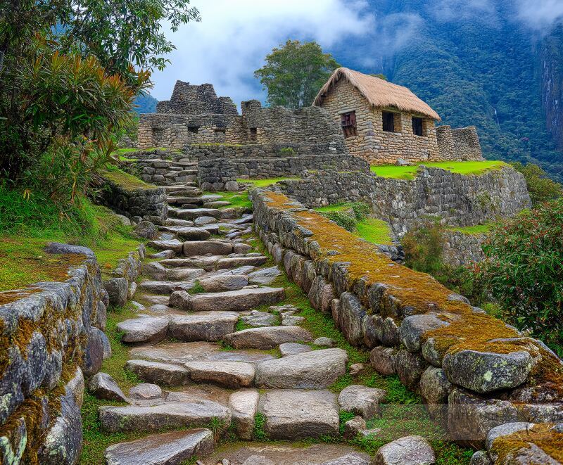 Discover the stunning Inca ruins of Machu Picchu in Peru with ancient stone structures nestled among lush green landscapes under a cloudy sky A perfect spot for history lovers