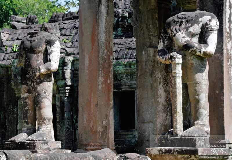 Visitors marvel at the ancient stone statues of Angkor Wat in Siem Reap Cambodia. The towering remnants from a long lost civilization evoke a sense of wonder and intrigue among the lush greenery.