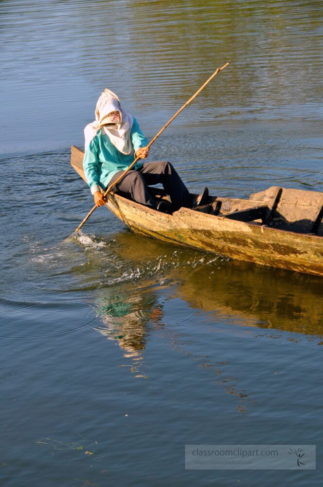 A fisherman navigates the calm waters of Siem Reap crafting his way through the reflections of nature. The tranquil setting near Angkor Wat captures the harmony between human life and the environment.