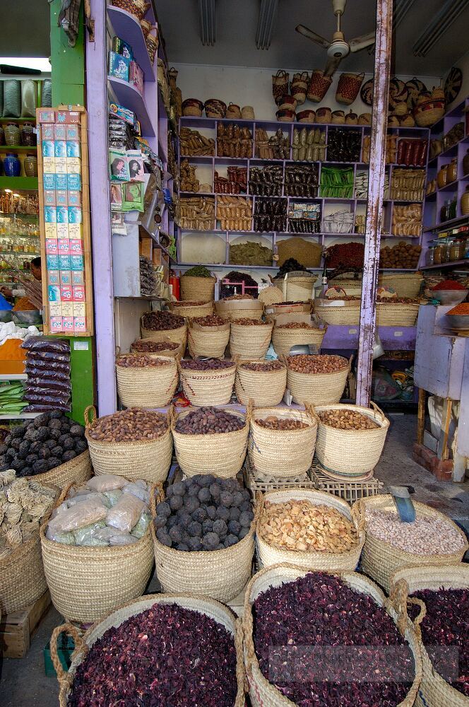 In Aswan Egypt a vibrant market showcases an array of spices in woven baskets displaying various colors and textures The shop is bustling with local traditions and aromas