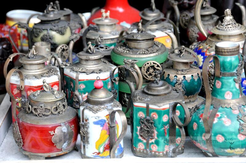 Discover an exquisite assortment of vintage ceramic tea pots on display in a vibrant marketplace in Singapore.