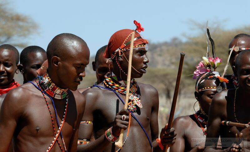 Members of the Samburu Tribe in Kenya participate in a vibrant cultural celebration Dressed in traditional attire they perform rituals and dance while holding sticks showcasing their rich heritage and community spirit under a clear blue sky