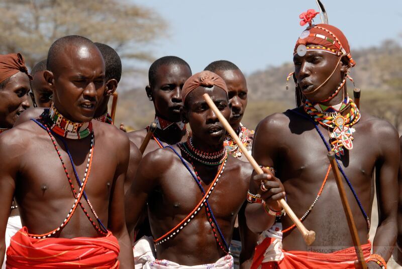 Members of the Samburu tribe in Kenya participate in a vibrant gathering showcasing their cultural attire and accessories The men adorned with traditional jewelry are engaged in activities that highlight their community spirit and customs