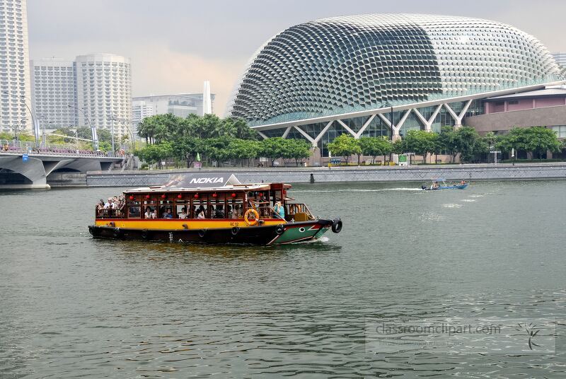 A colorful tourist boat glides along the calm waters of Singapore, surrounded by sleek skyscrapers and modern architecture, capturing the essence of urban adventure and leisure.