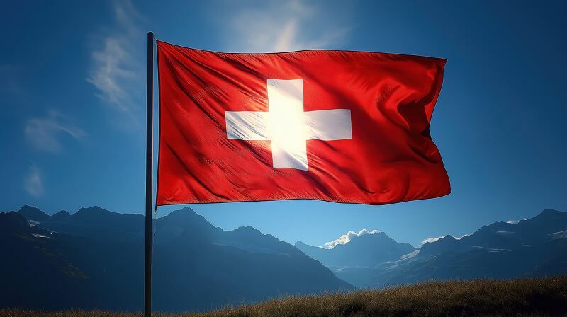 A vibrant Swiss flag stands tall fluttering in the wind amidst a stunning mountain landscape The scene captures the essence of Switzerlands natural beauty and national pride