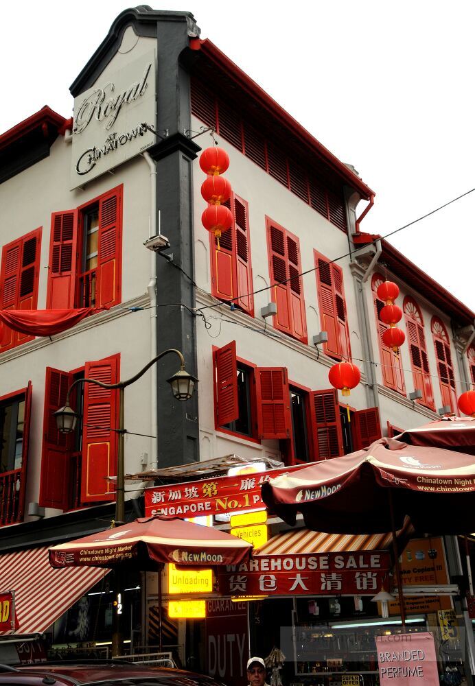 A colorful building adorned with red lanterns captures the essence of Singapore’s rich heritage. The bustling atmosphere invites exploration of the vibrant streets and local treasures.