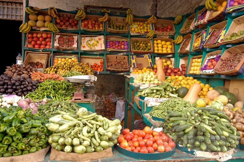 A bustling market stall in Aswan Egypt showcases a colorful array of fresh fruits and vegetables Local vendors arrange the produce attractively inviting shoppers to browse