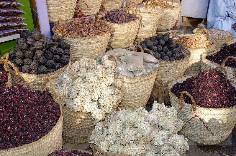 Colorful baskets filled with various spices and dried herbs are showcased in a lively market in Aswan Local vendors sell their goods attracting shoppers with enticing aromas