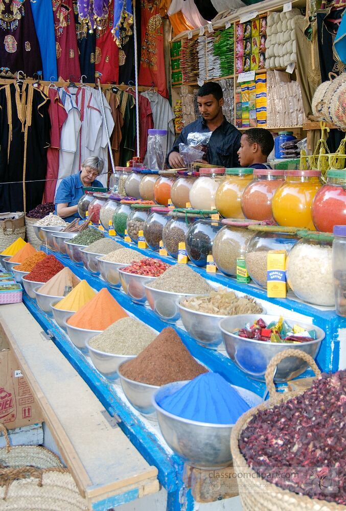 A lively market in Aswan Egypt showcases colorful spices arranged in bowls Local vendors interact with customers highlighting the rich culture and flavors of the region