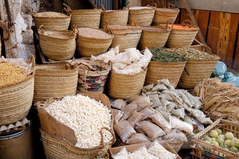 Colorful woven baskets filled with various spices and herbs create a rich tapestry of sights in an Aswan market The bustling atmosphere reflects local culture and trade