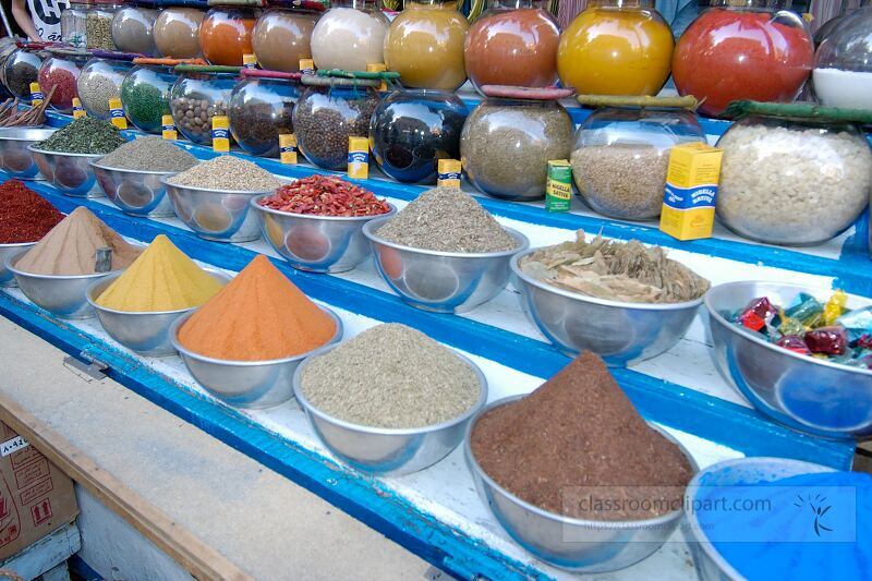 Colorful bowls filled with various spices are displayed prominently in an Aswan market Local vendors invite shoppers to explore rich aromas and unique ingredients enhancing culinary experiences