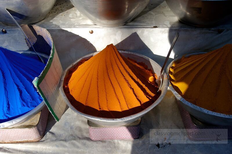 Colorful piles of spices are displayed at a local market in Aswan Egypt The vibrant blue orange and yellow powders attract visitors showcasing the regions culinary heritage